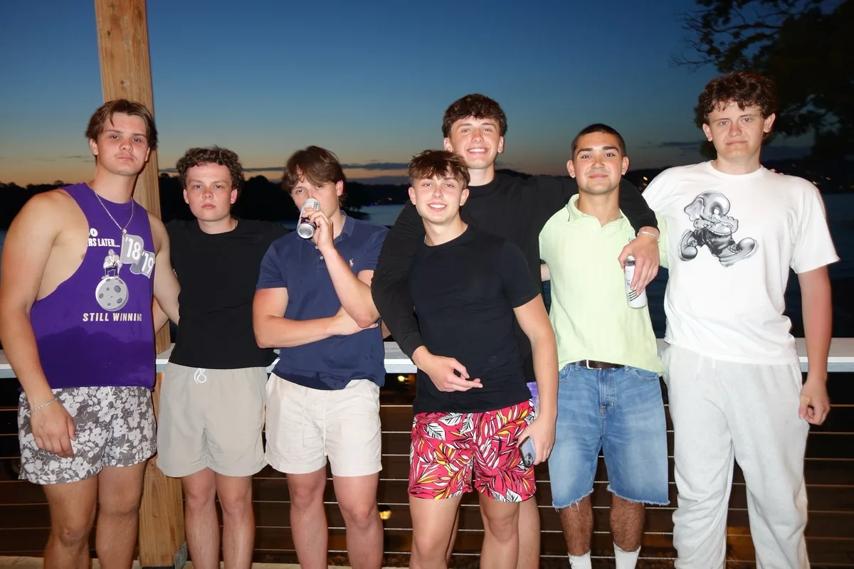 A group of friends together beside a lake at dusk