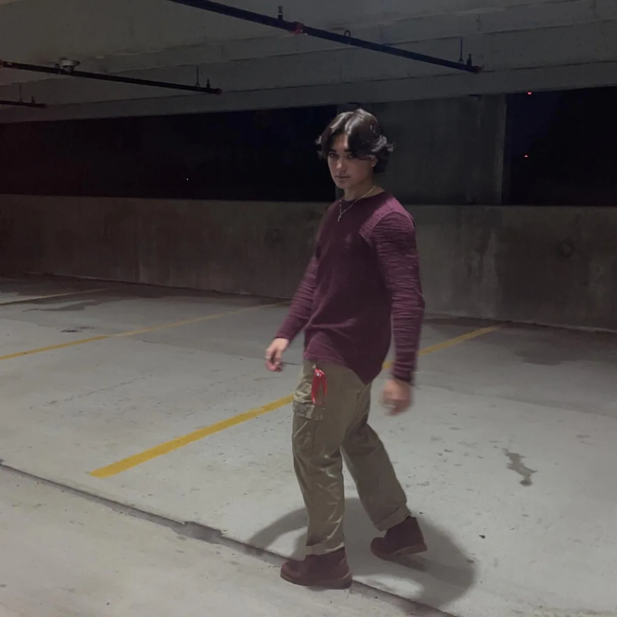 Walking through a parking garage in a burgundy top