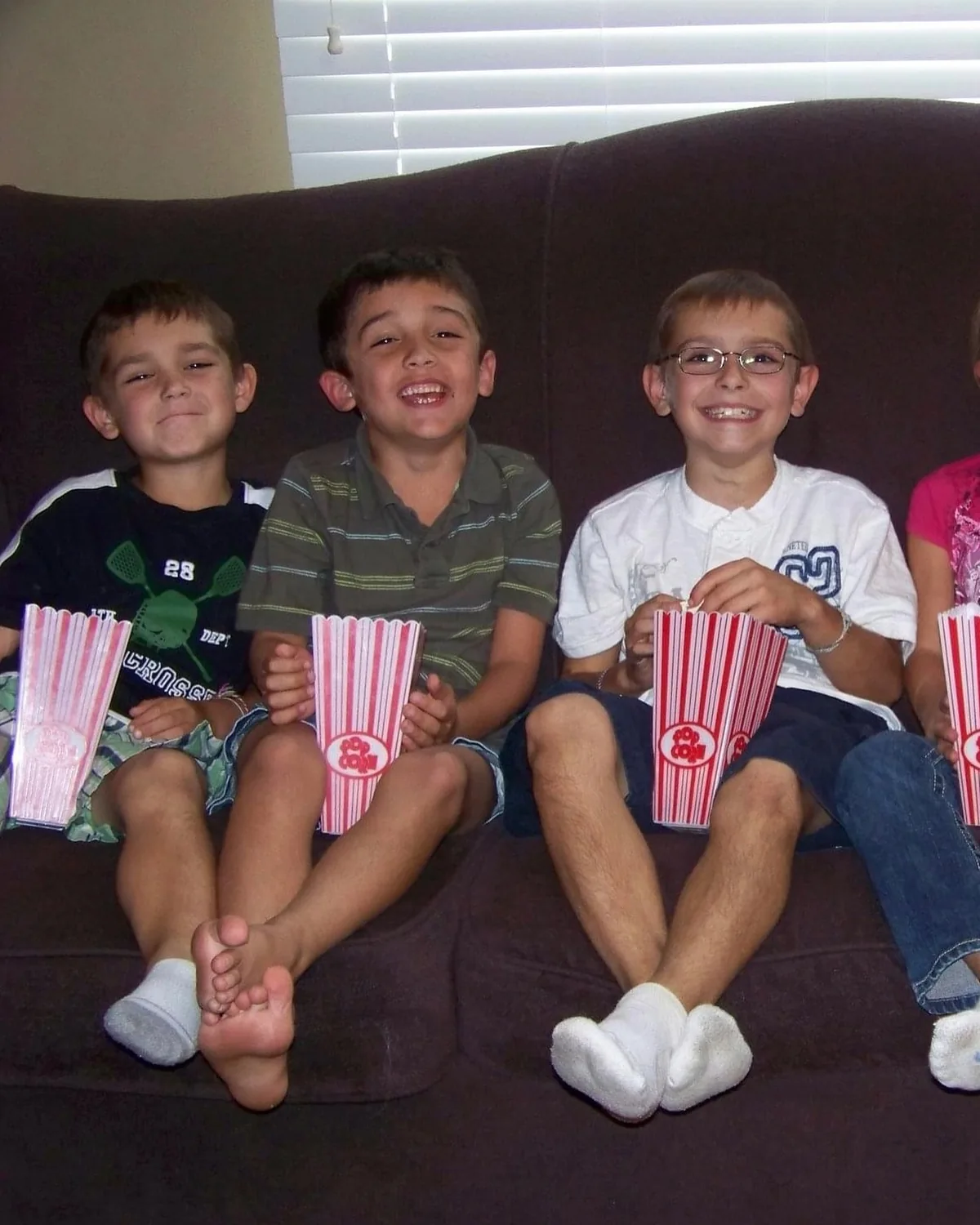 An early photograph of children with popcorn on a sofa