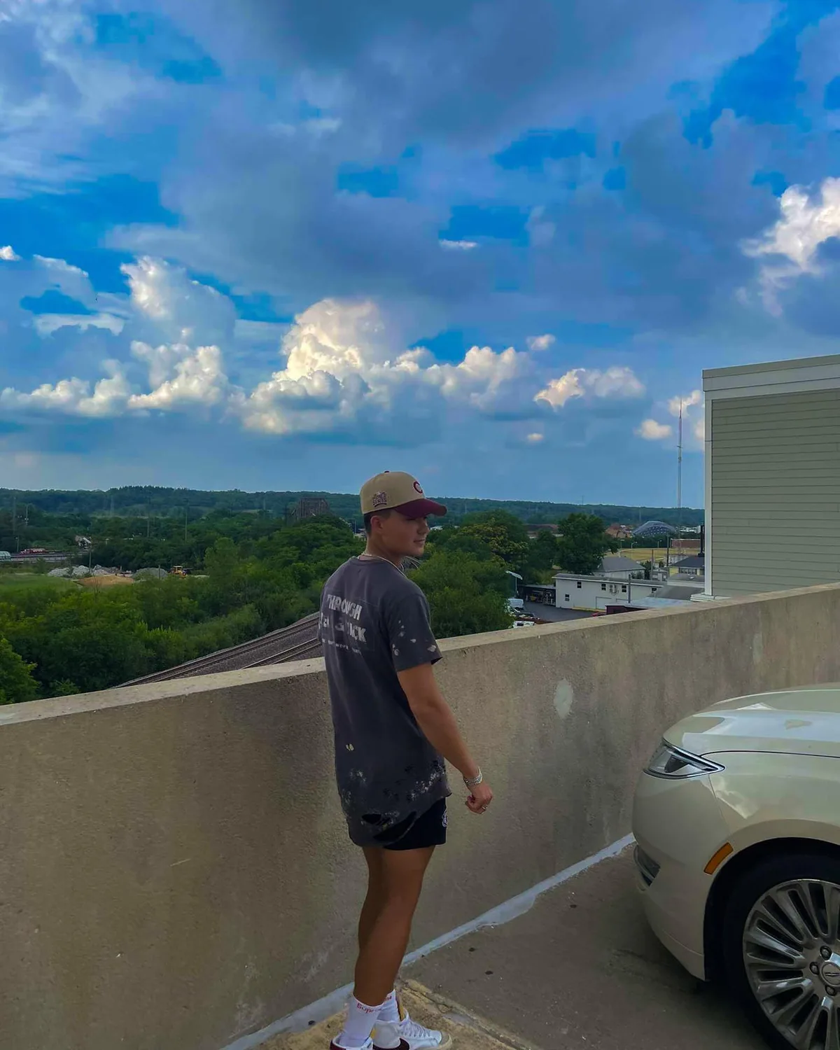 Alex on a rooftop under a sky filled with clouds