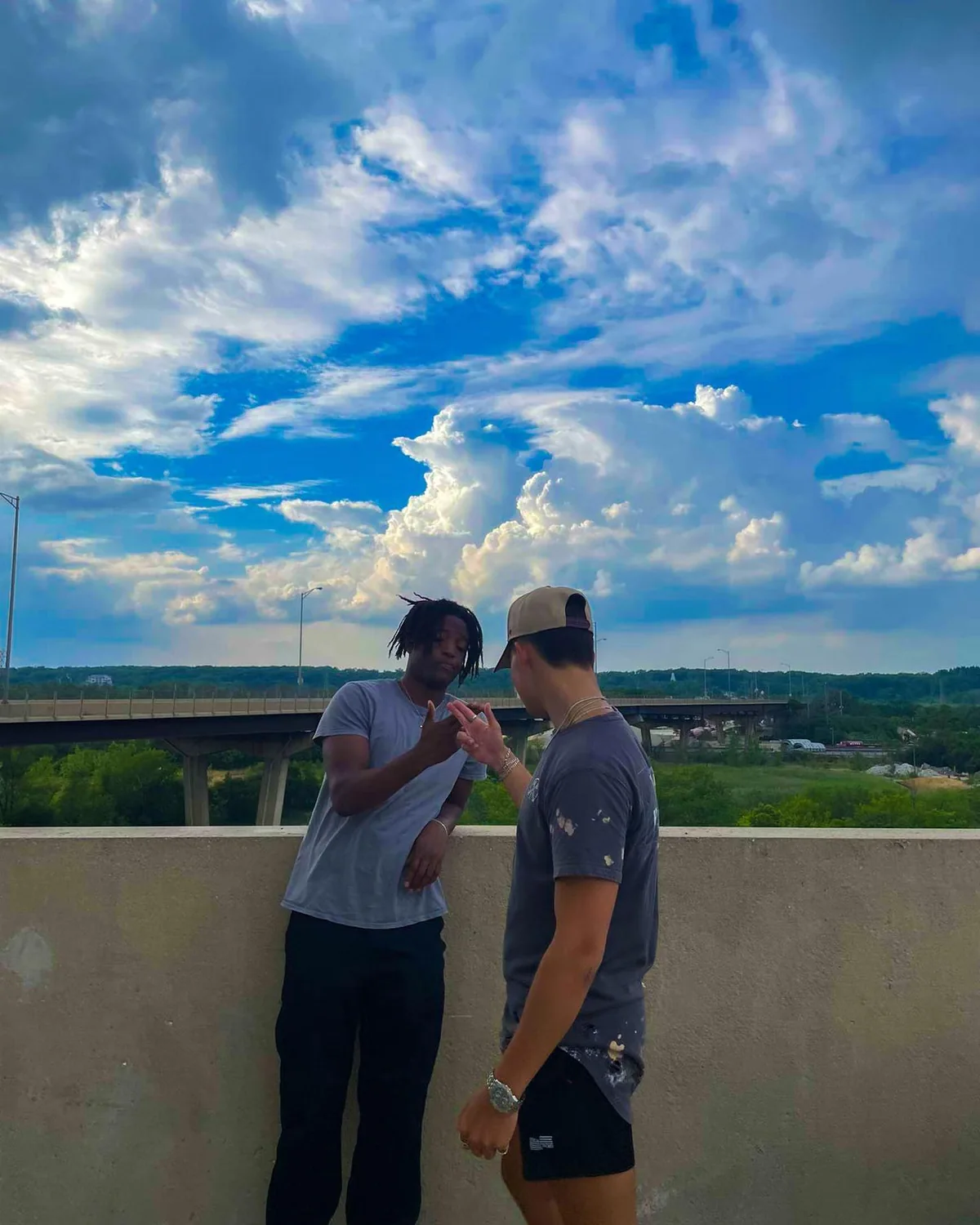 Two friends on a rooftop beneath a blue sky
