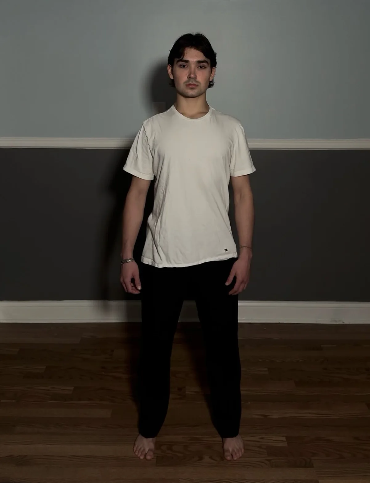 Alex in a white shirt against a neutral wall