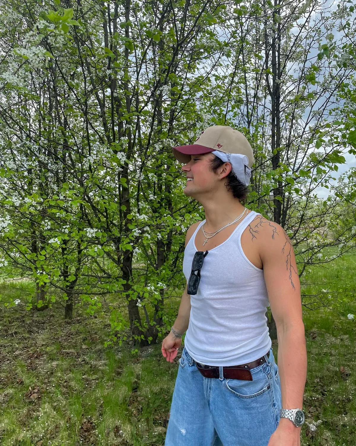 Alex standing in a green wooded setting