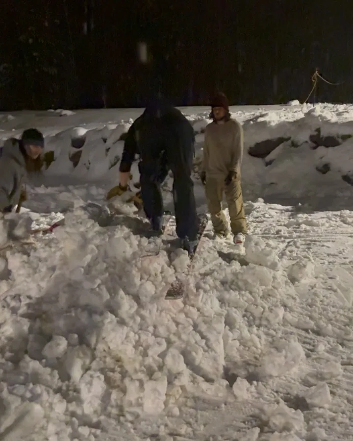 Friends gathered outside in the snow at night